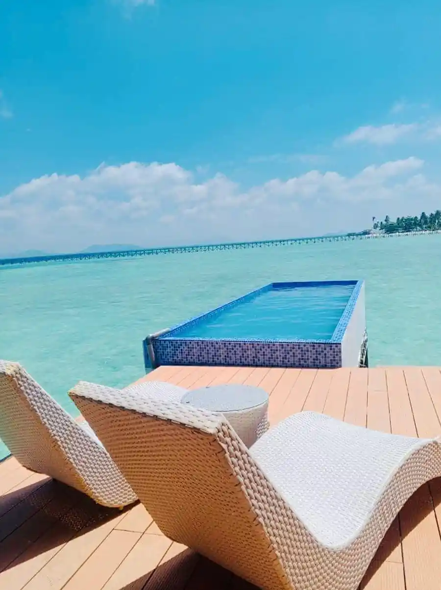 Private infinity plunge pool and sun loungers on the deck of the Bedroom Deluxe 1 Bed at Turtle Seaweed Resort, overlooking the clear turquoise sea.